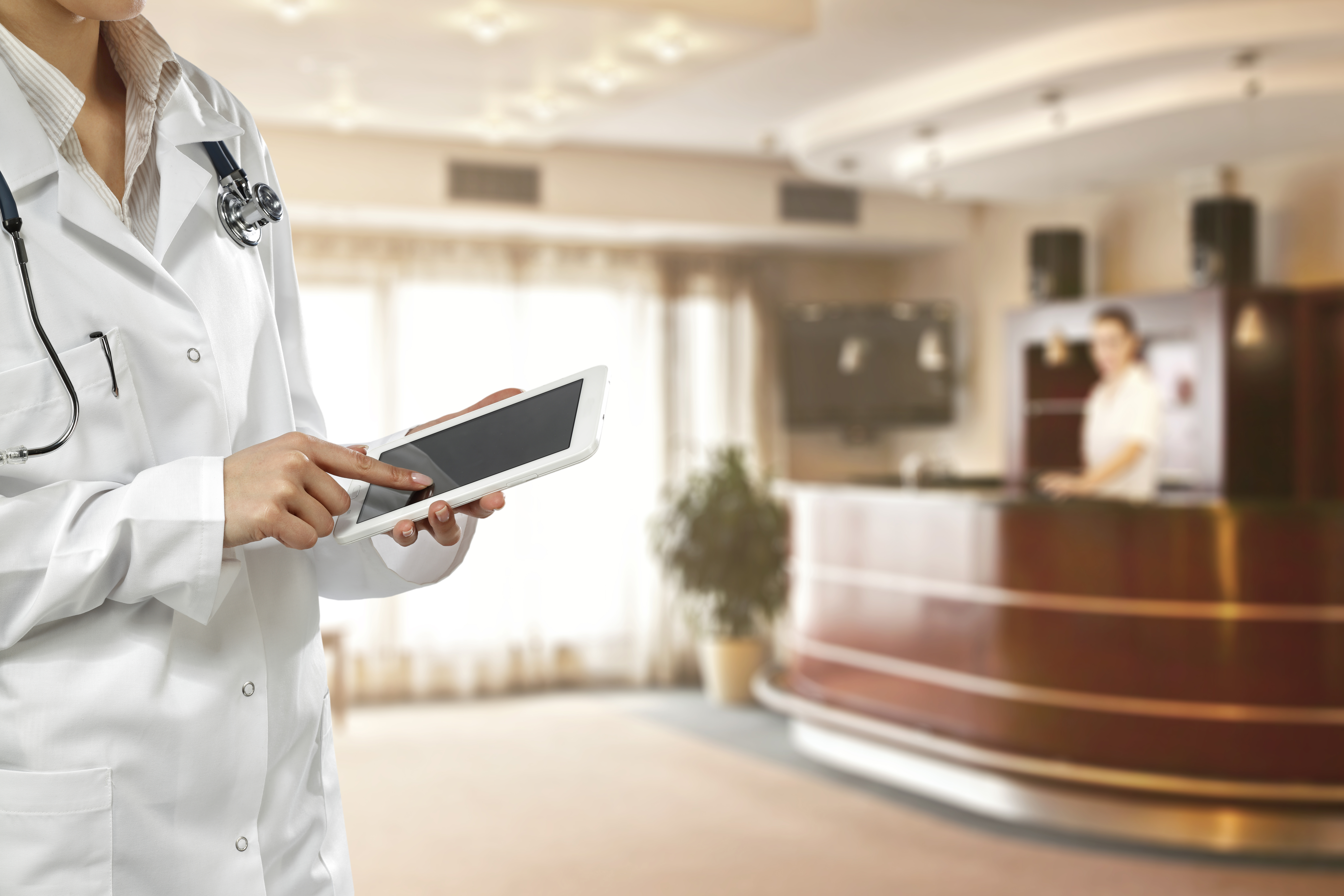 Doctor with tablet in hospital lobby